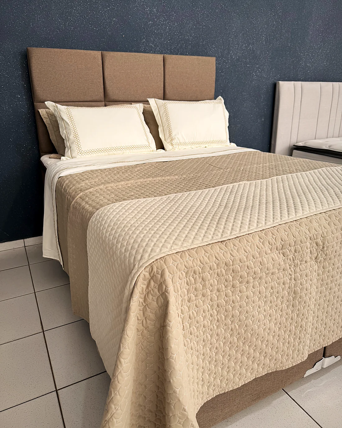 Cama arrumada com colcha, lençóis e travesseiros dos enxovais da House